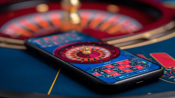 Um homem comemorando uma vitória em seu laptop enquanto símbolos de jogos flutuam ao redor, capturando a emoção dos jogos 615BET.