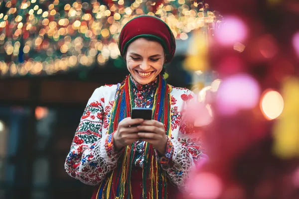 Uma mulher em um vestido verde luxuoso ao lado de uma roleta ornamentada, capturando o clima sofisticado do 615BET.